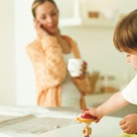  Bambino con mamma preoccupata al telefono.